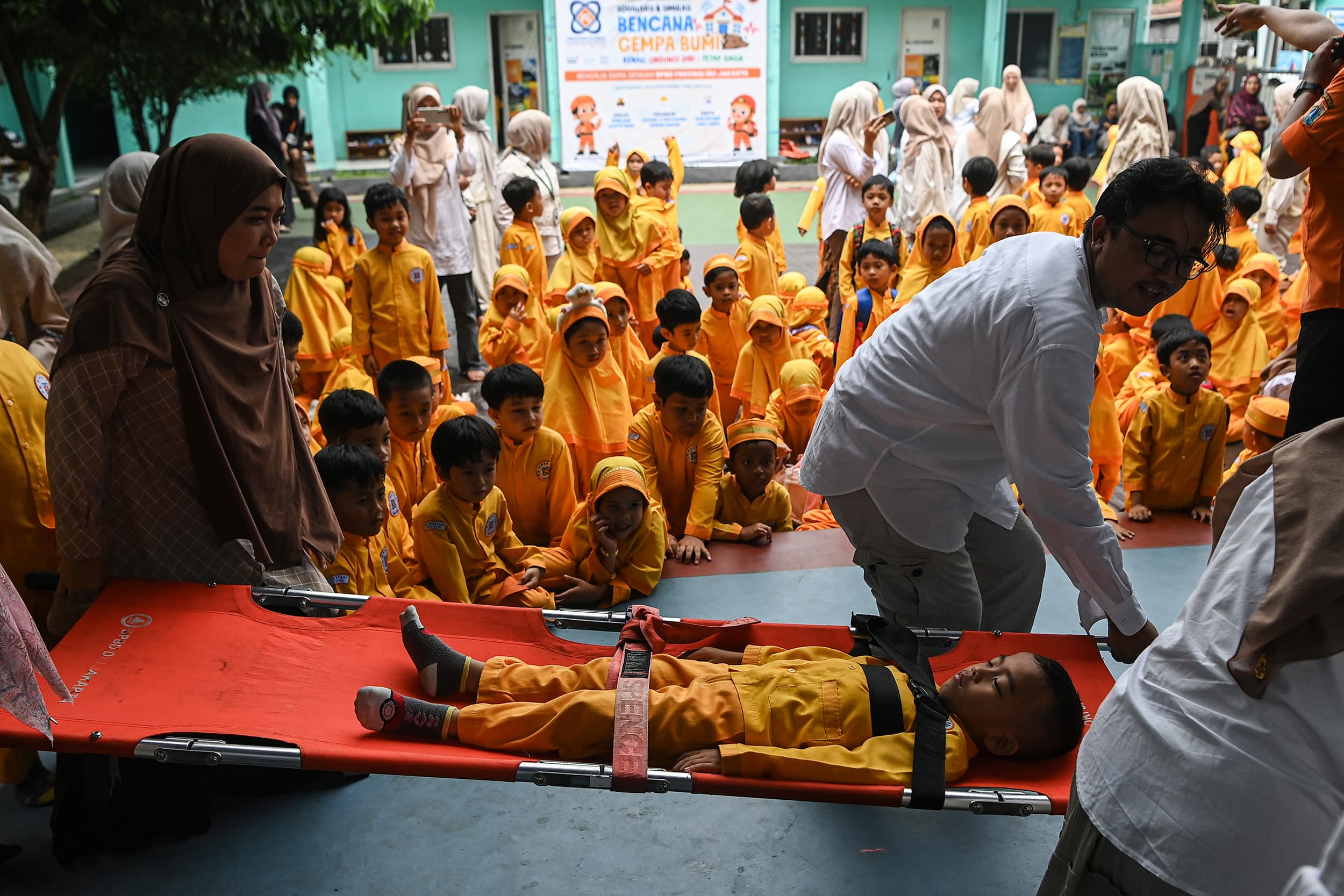Sejumlah guru mengevakuasi seorang murid saat simulasi penanganan bencana gempa bumi di KB-TK Prestasi Global, Depok, Jawa Barat, Jumat (30/10/2026). ANTARA FOTO/Sigid Kurniawan/rwa.