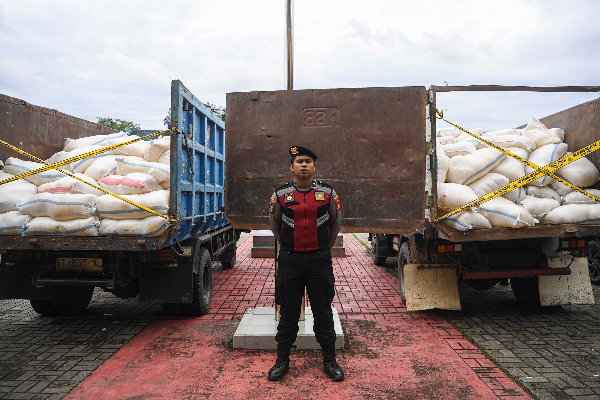 Anggota Polisi berdiri diantara barang bukti minuman keras tradisional di dalam truk saat ungkap kasus Operasi Pekat Mahakam 2026 di Mapolresta Samarinda, Samarinda, Kalimantan Timur, Selasa (24/2/2026).