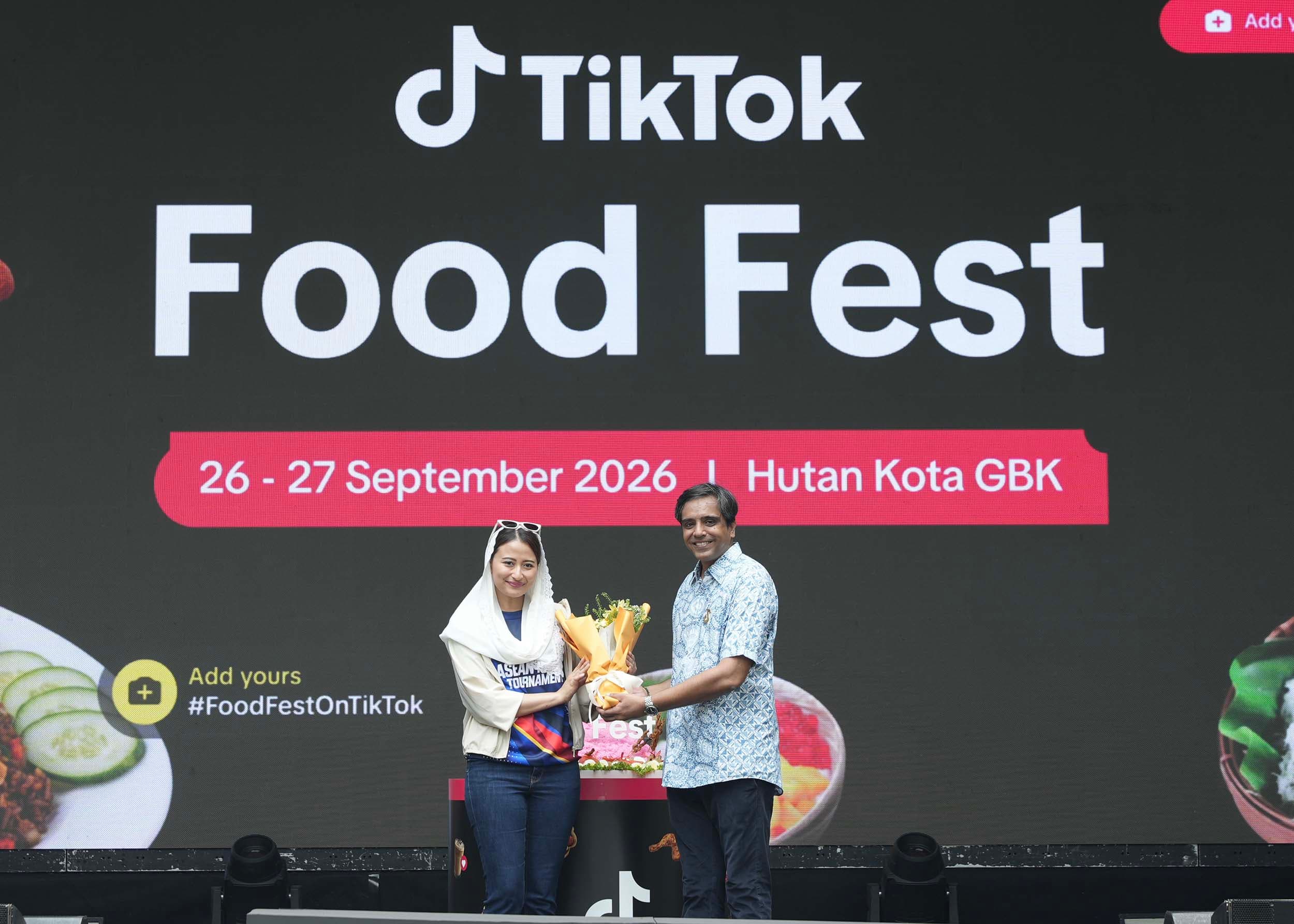 Dyah Roro Esti Widya Putri, Wakil Menteri Perdagangan Republik Indonesia (kiri) dan Zaheer Travadi, Head of Industry, TikTok Indonesia (kanan) melakukan pemotongan nasi tumpeng untuk meresmikan Pembukaan TikTok Food Fest 2026 di Hutan Kota GBK, Jakarta, pada Sabtu (26/9).