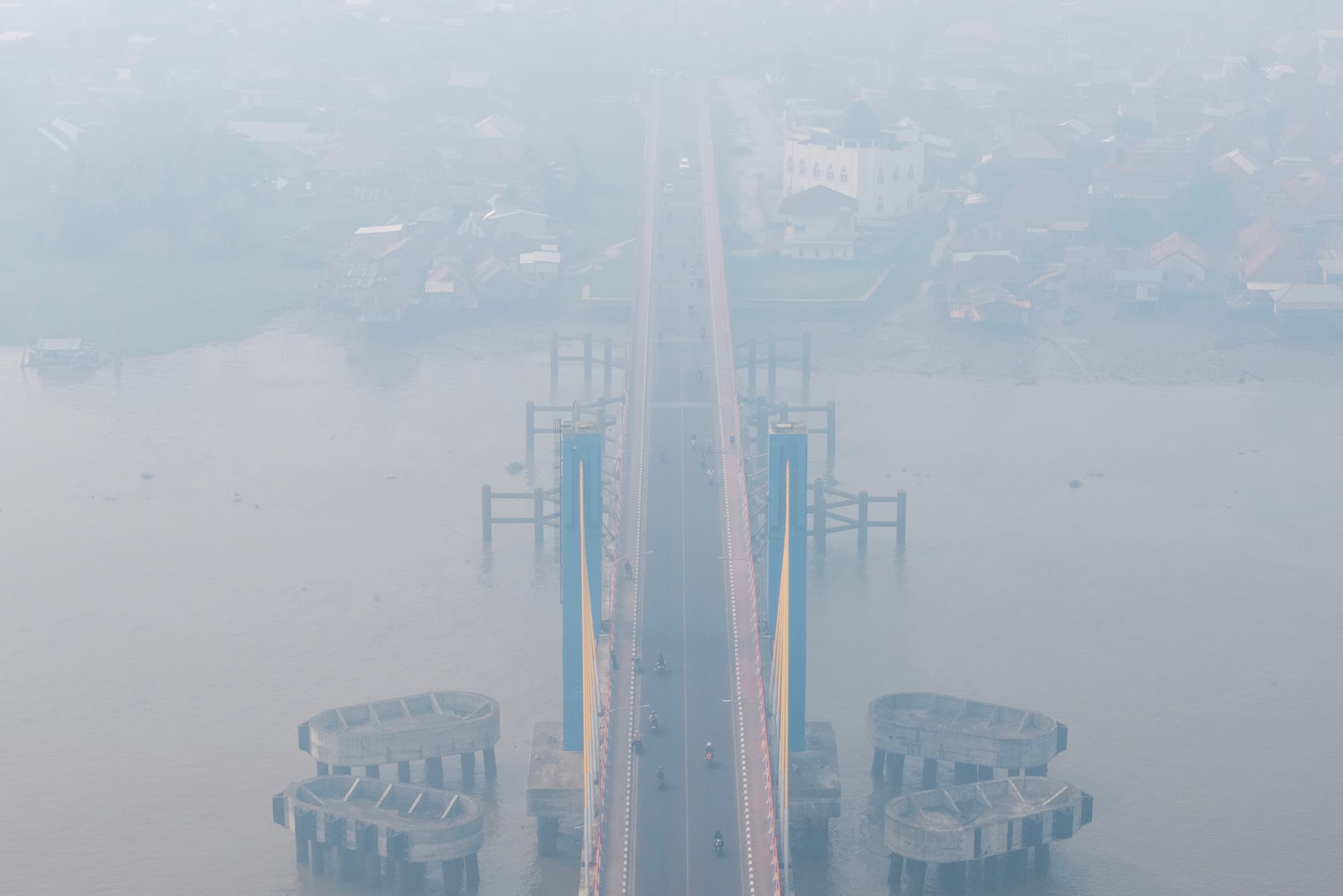 Foto udara sejumlah pengendara melintas di atas jembatan Musi IV Palembang yang tertutup kabut asap di Palembang, Sumatera Selatan, Minggu (4/10/2026). ANTARA FOTO/Nova Wahyudi/YU